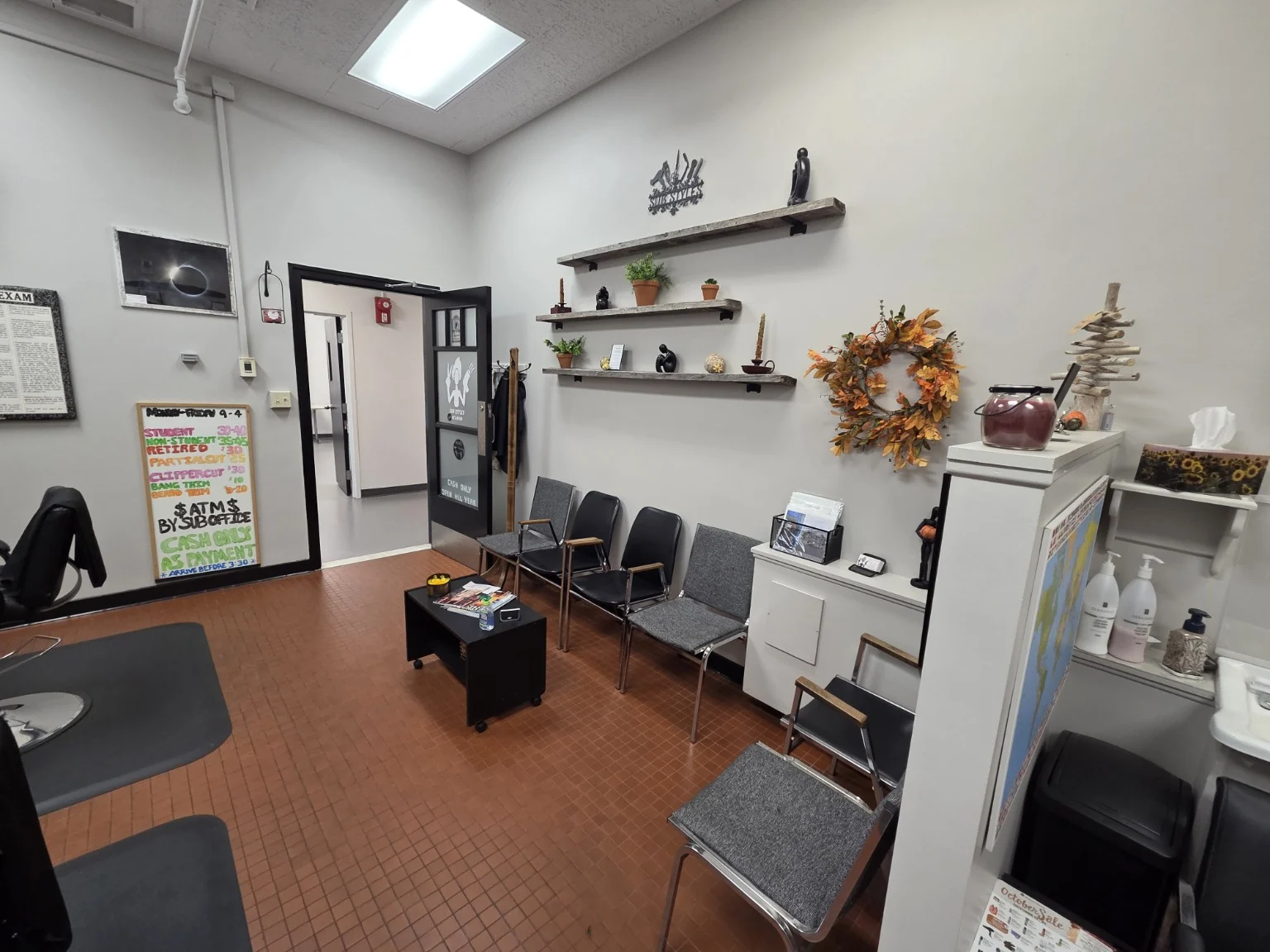 The waiting area inside SUB Styles, with chairs and shelves.