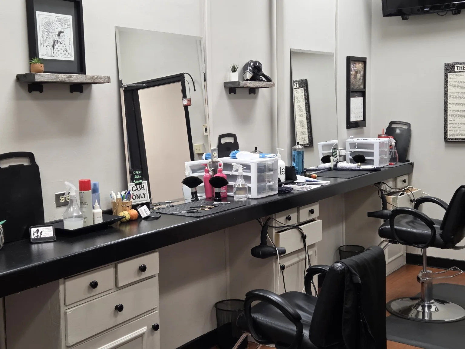 The salon's styling stations, mirrors and tools ready for a haircut.
